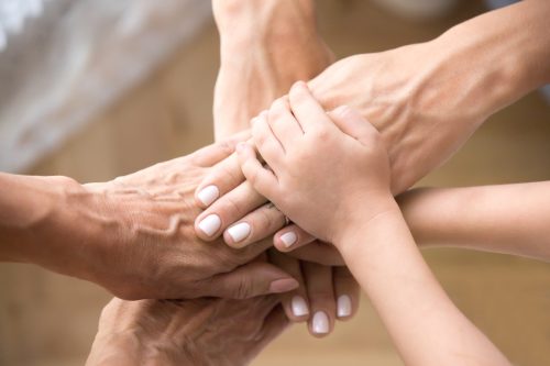 Hands of three generations stacked together